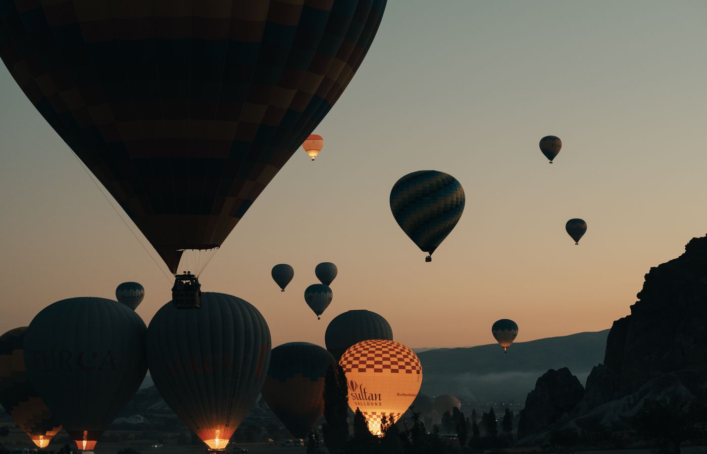 Gün doğumunda gökyüzünü dolduran sıcak hava balonları